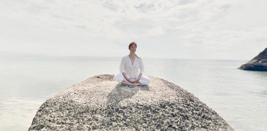 Susanne Peter sitzt hier entspannt am Meer und fokussiert sich auf ihren Atem. Dies können Sie auch bei ihr in ihren Kursen und Einzelsitzungen lernen